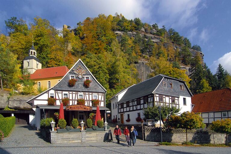 Der Berg Oybin mit der Bergkirche. Im Vordergrund Umgebindehäuser.