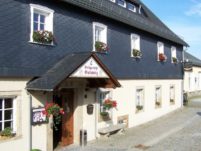 Das Gebäude des Erbgerichtes Eulowitz mit blumengeschmücktem Eingang.