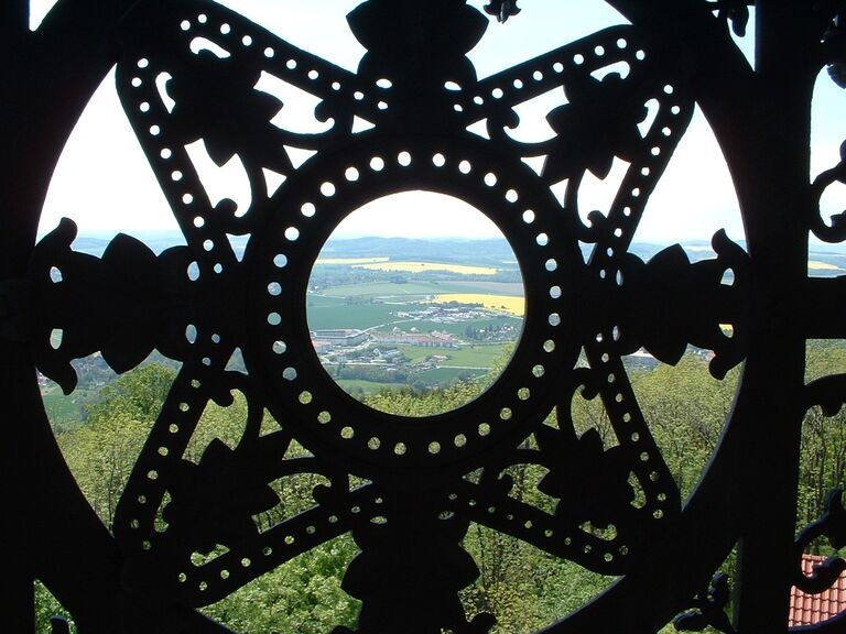 Kunstgebilde des Gusseisernen Turms in Löbau. Im Hintergrund ist die Aussicht vom Löbauer Berg zu sehen.