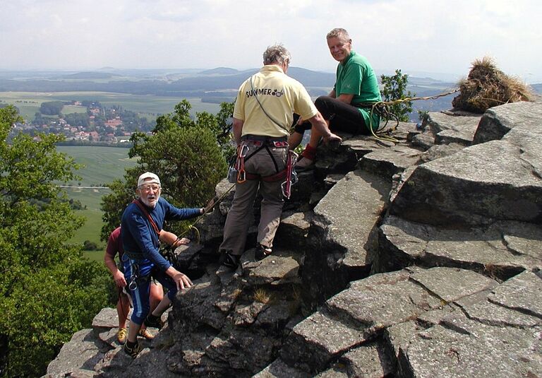Drei Kletterer erklimmen den Felsen am Gipfel des Spitzberges.