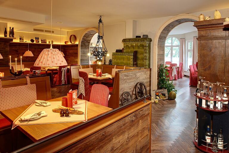 Der gemütlich eingerichtete Innenraum des Restaurant bei Schumann. Der Boden und die Sitzbänke der Gäste aus dunklem Holz.