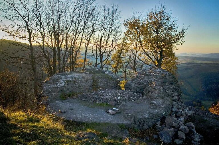 Die Ruine der Burg Rogowiec, hinter der sich ein weiter Ausblick auf die umliegende Gegend auftut.