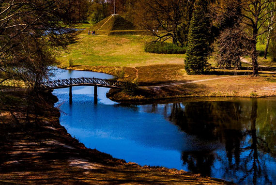 kleiner Fluss mit Holz-Brücke und ein paar Bäumen